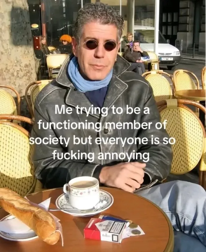 Meme of a man in sunglasses and a leather jacket at an outdoor café table with coffee, a baguette and cigarettes, captioned: Me trying to be a functioning member of society but everyone is so fucking annoying