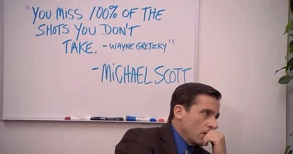 Michael Scott in The Office, sitting under a whiteboard that reads: “You miss 100% of the shots you don’t take. – Wayne Gretzky” – Michael Scott